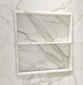 Square marble shower niche with one marble shelf and set slightly forward of the surrounding wall tile