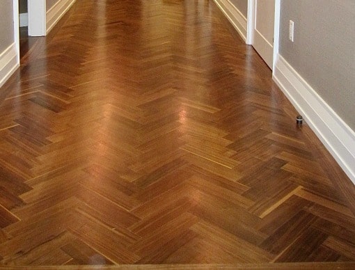 Lattice used as shoe molding and painted white on herrignbone floor