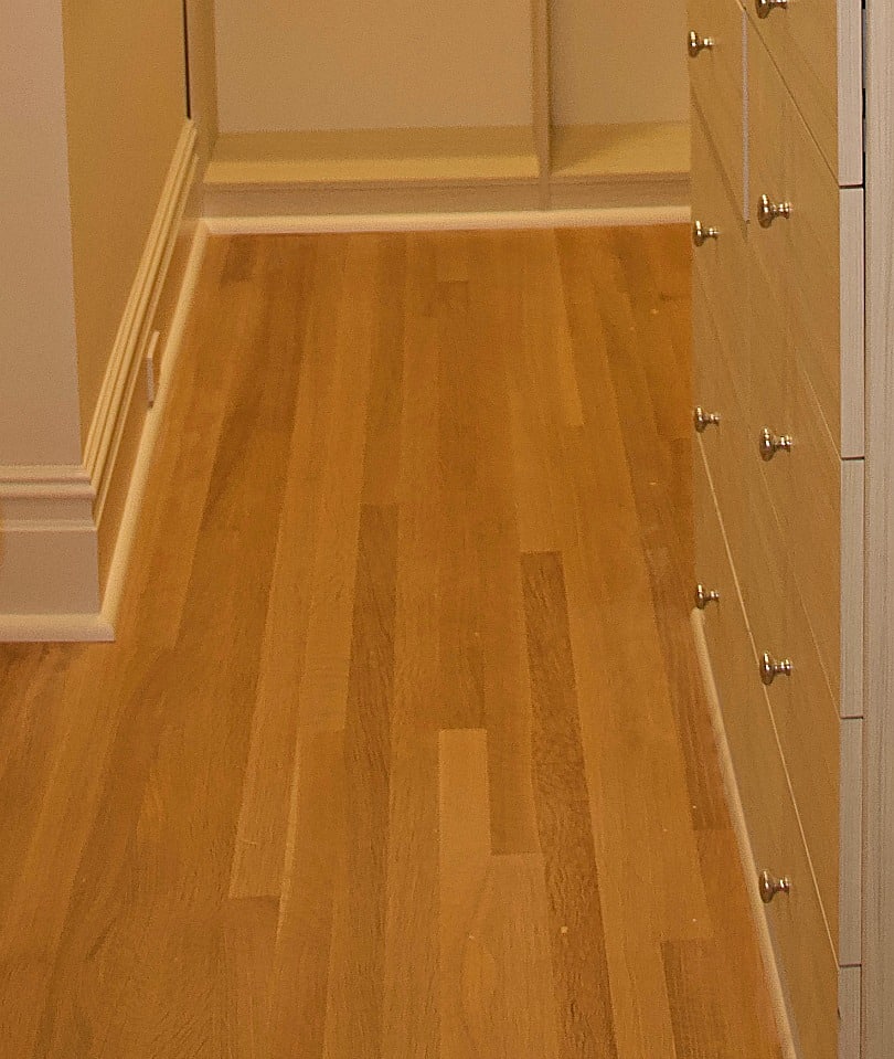 Roundover shoe molding on hardwood floor inside a walk-in closet
