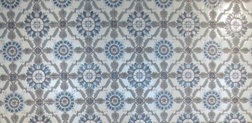 Backsplash tile with a blue and grey painted pattern 