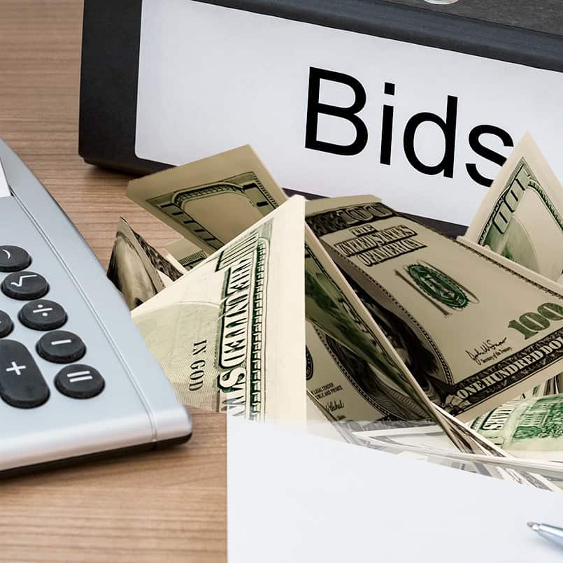 Bids sign on desktop with calculator and hundred dollar bids